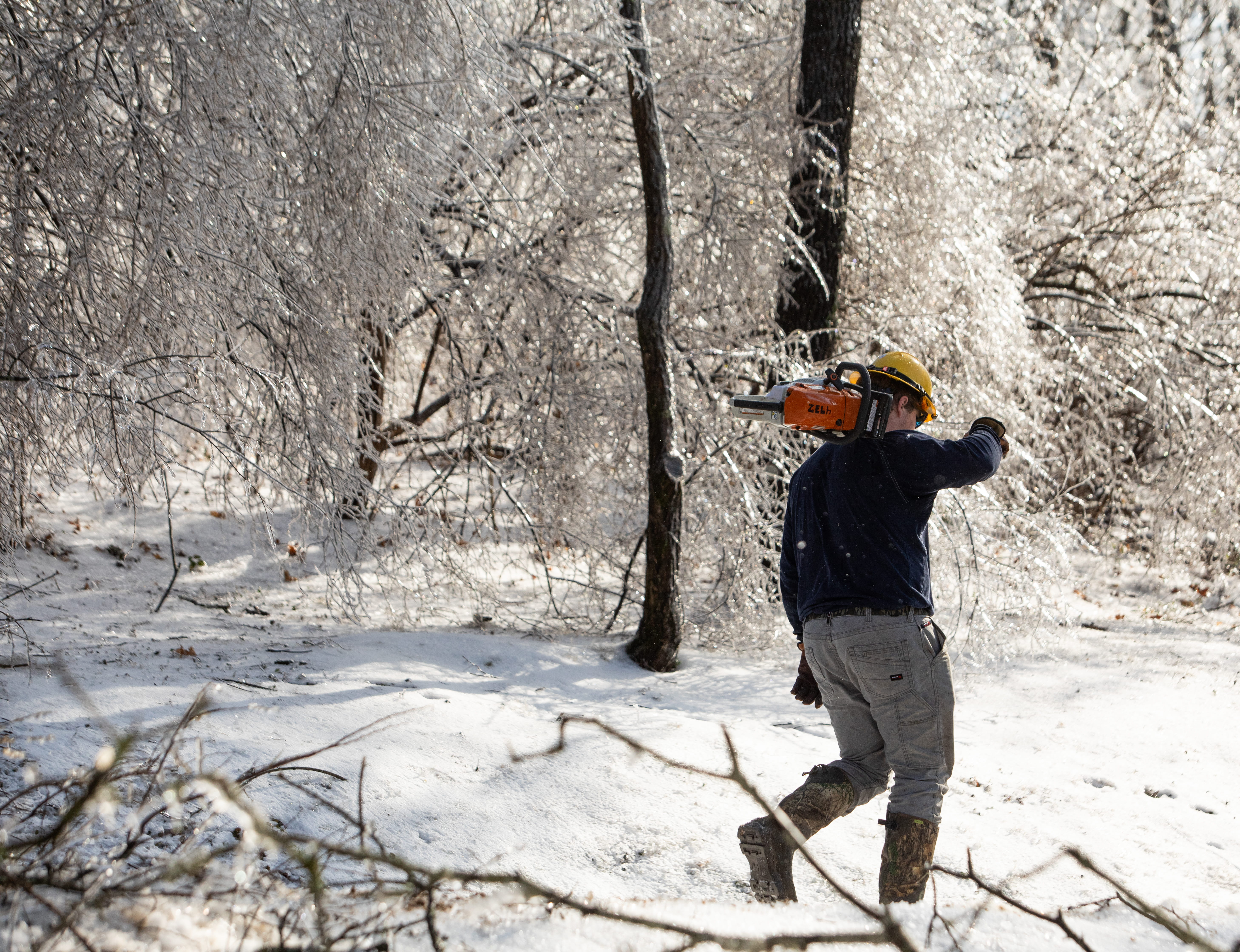 man walking with chainsaw during storm